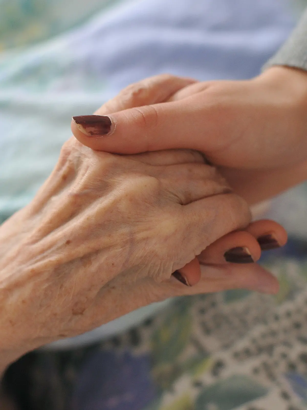 ARCHIV - Eine junge Frau hält am 15.02.2011 die Hände einer alten Frau, die in einem Rollstuhl in einem Seniorenheim sitzt. Die gesetzliche Darlehensregelung für pflegende Angehörige, die berufstätig sind, ist nach Ansicht der Deutschen Stiftung Patientenschutz gescheitert. (zu dpa «Stiftung: Pflegedarlehen funktionieren nicht» vom 27.01.2018) Foto: Patrick Pleul/dpa-Zentralbild/dpa +++ dpa-Bildfunk +++