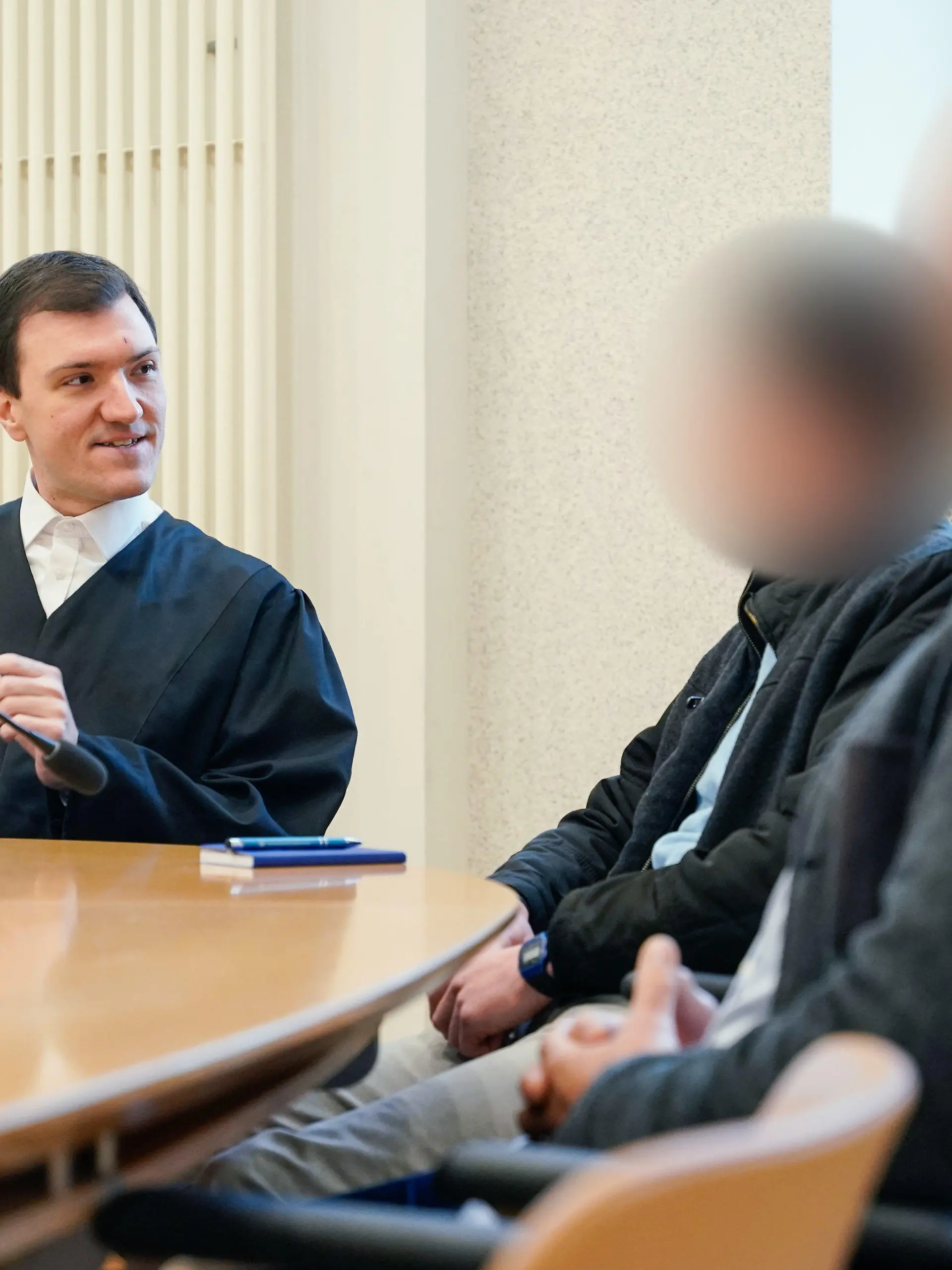 07.12.2023, Baden-Württemberg, Mannheim: Rechtsanwalt Timo van der Does (l) spricht mit den beiden Angeklagten im Verhandlungssaal des Amtsgerichts. Sie sollen getrennt voneinander und zu unterschiedlichen Zeitpunkten Pferde unter anderem mit einer Reitgerte oder der flachen Hand geschlagen haben. Einer soll einem Pferd zudem einen mit leeren Konserven- beziehungsweise Getränkedosen gefüllten Jutesack angebunden und so das Wohlbefinden des Tieres durch die lauten Klappergeräusche «nicht unerheblich beeinträchtigt» haben. Foto: Uwe Anspach/dpa - ACHTUNG: Person(en) wurde(n) aus rechtlichen Gründen gepixelt +++ dpa-Bildfunk +++