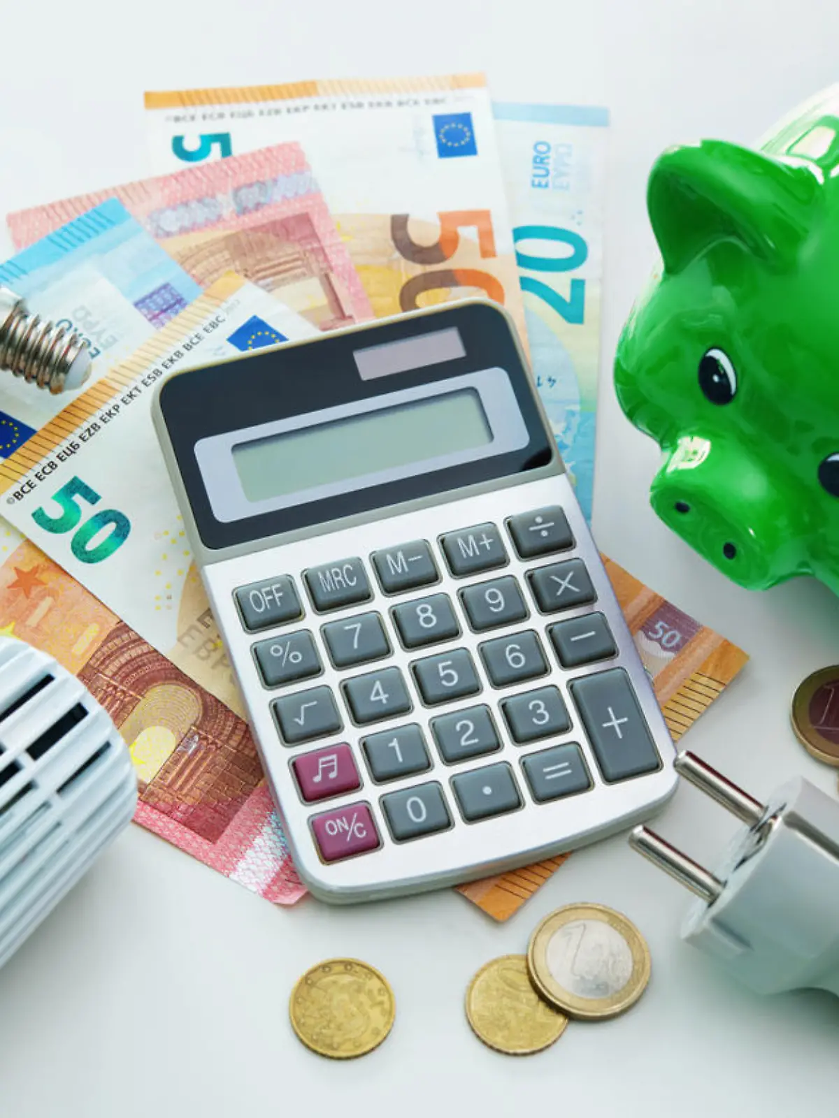 Energy cost, saving energy concept. Piggy bank, calculator and money, plug, bulb and radiator thermostat on white background