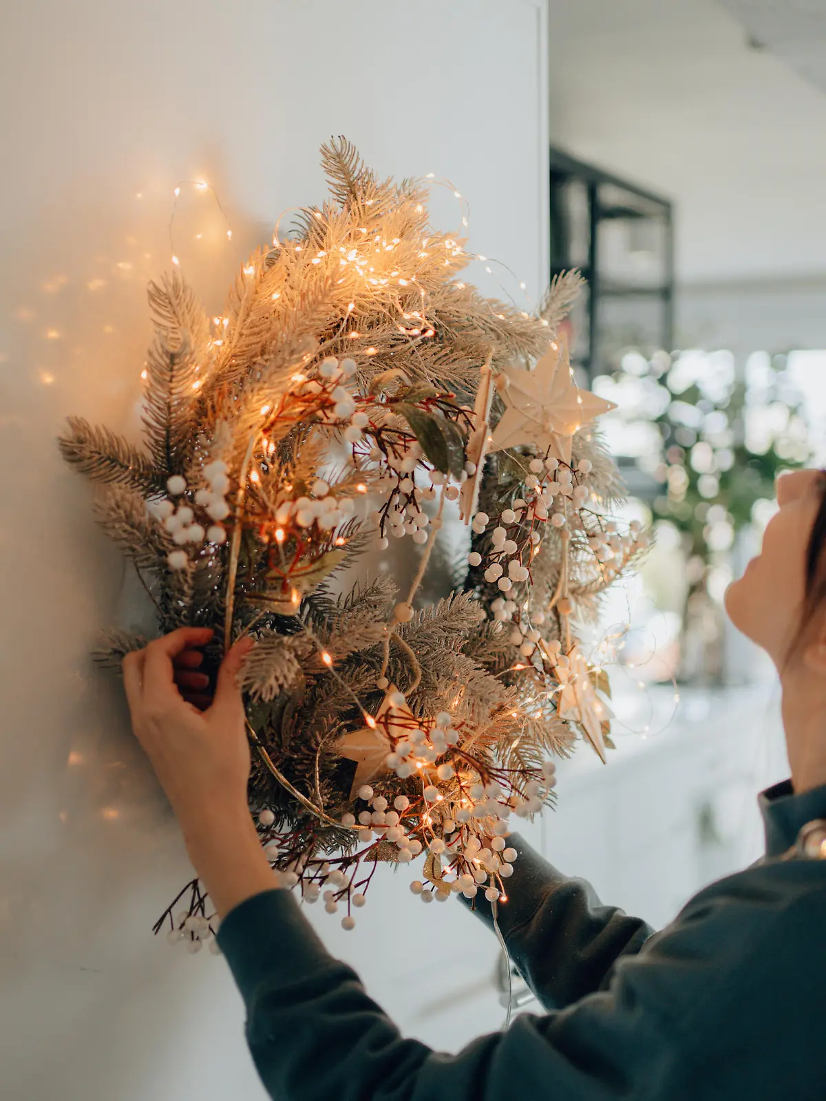 Photo of a young woman decorating the living room of her apartment; getting ready for the upcoming holiday season.