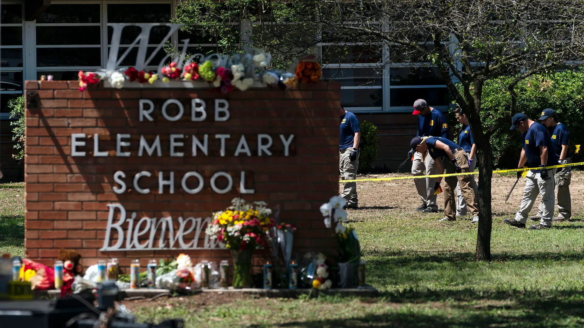 FILE - Investigators search for evidences outside Robb Elementary School in Uvalde, Texas, May 25, 2022, after an 18-year-old gunman killed 19 students and two teachers.  Four months after the Robb Elementary School shooting, the Uvalde school district on Friday, Oct. 7 pulled its entire embattled campus police force off the job following a wave of new outrage over the hiring of a former Texas state trooper who was part of the hesitant law enforcement response as a gunman killed 19 children and two teachers.(AP Photo/Jae C. Hong, File)