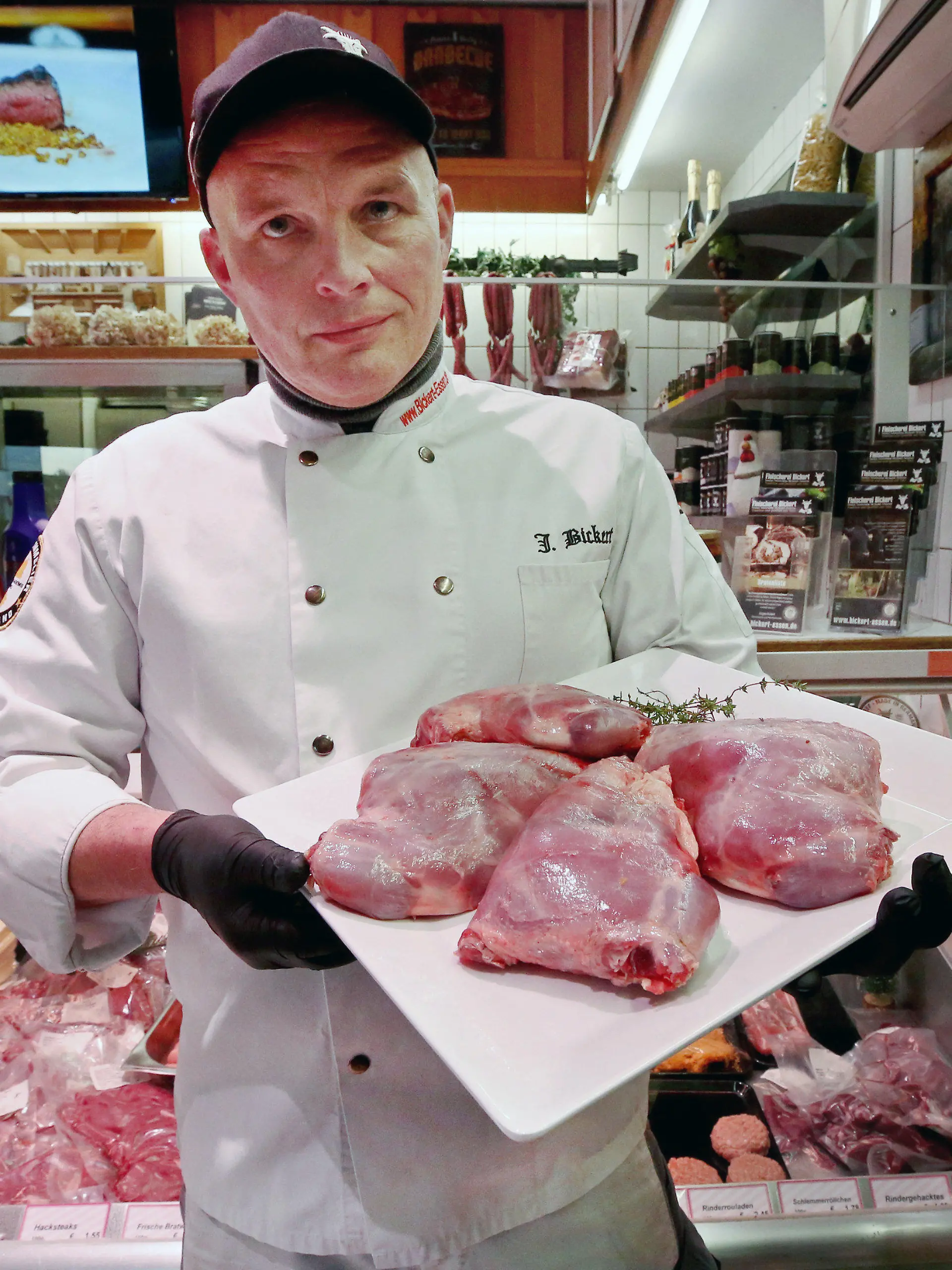 PRODUKTION - 08.12.2023, Nordrhein-Westfalen, Essen: Jürgen Bickert, Metzgermeister und geprüfter "Fleischsommelier", präsentiert in seiner Metzgerei Nutria-Keulen. Nutrias gelten als invasive Art und werden mit Fallen bejagt. Jürgen Bickert empfiehlt die geschmorten Keulen als Weihnachtsbraten.       (zu dpa "Metzger empfiehlt Nutria-Keule zu Weihnachten - «herrliches Fleisch»") Foto: Roland Weihrauch/dpa +++ dpa-Bildfunk +++