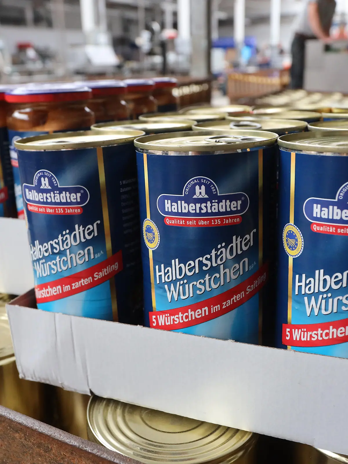 Konserven mit frisch geräucherten Würstchen und Suppen stehen in der Versandabteilung. Die Halberstädter Würstchen- und Konservenvertriebs GmbH bleiben trotz Corona weiterhin Marktführer bei den konservierten Würstchen in den neuen Bundesländern. Als Marke hat sich das Unternehmen mit 178 Beschäftigten einen Namen gemacht. Neben den traditionell kamingeräucherten Würstchen werden auch Suppen und andere konservierte Lebensmittel hergestellt.