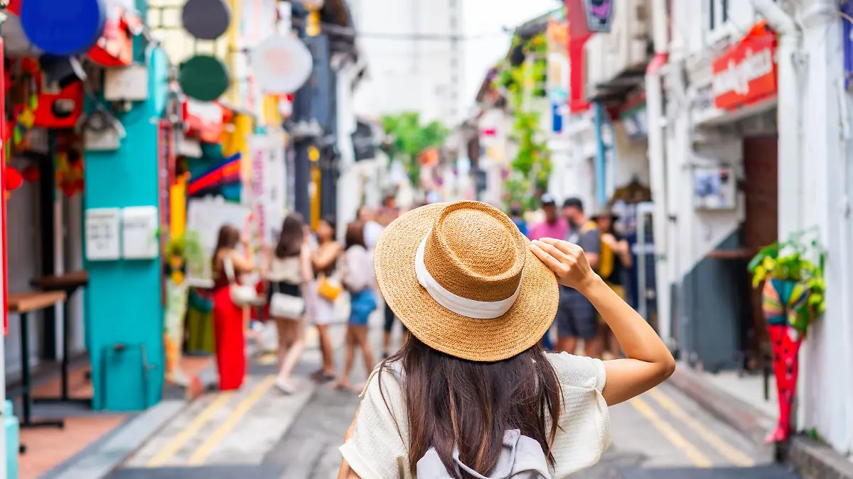 Young woman tourist with backpack walking at Haji Lane in Singapore