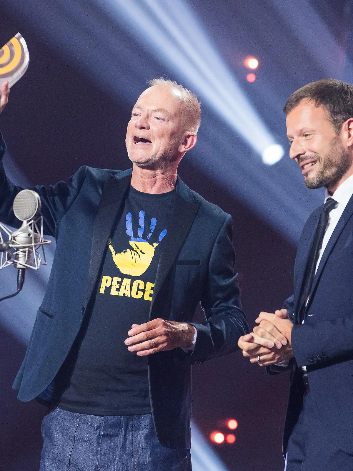 Während der Verleihung des Deutschen Radiopreises 2022 stehen Mike Thiel (l.) und Johannes Ott vom Sender Radio Gong 96,3 auf der Bühne mit dem Preis in der Kategorie «Beste Programmaktion» für «Gong 96.3 - München hilft. Unterkünfte für ukrainische Familien».