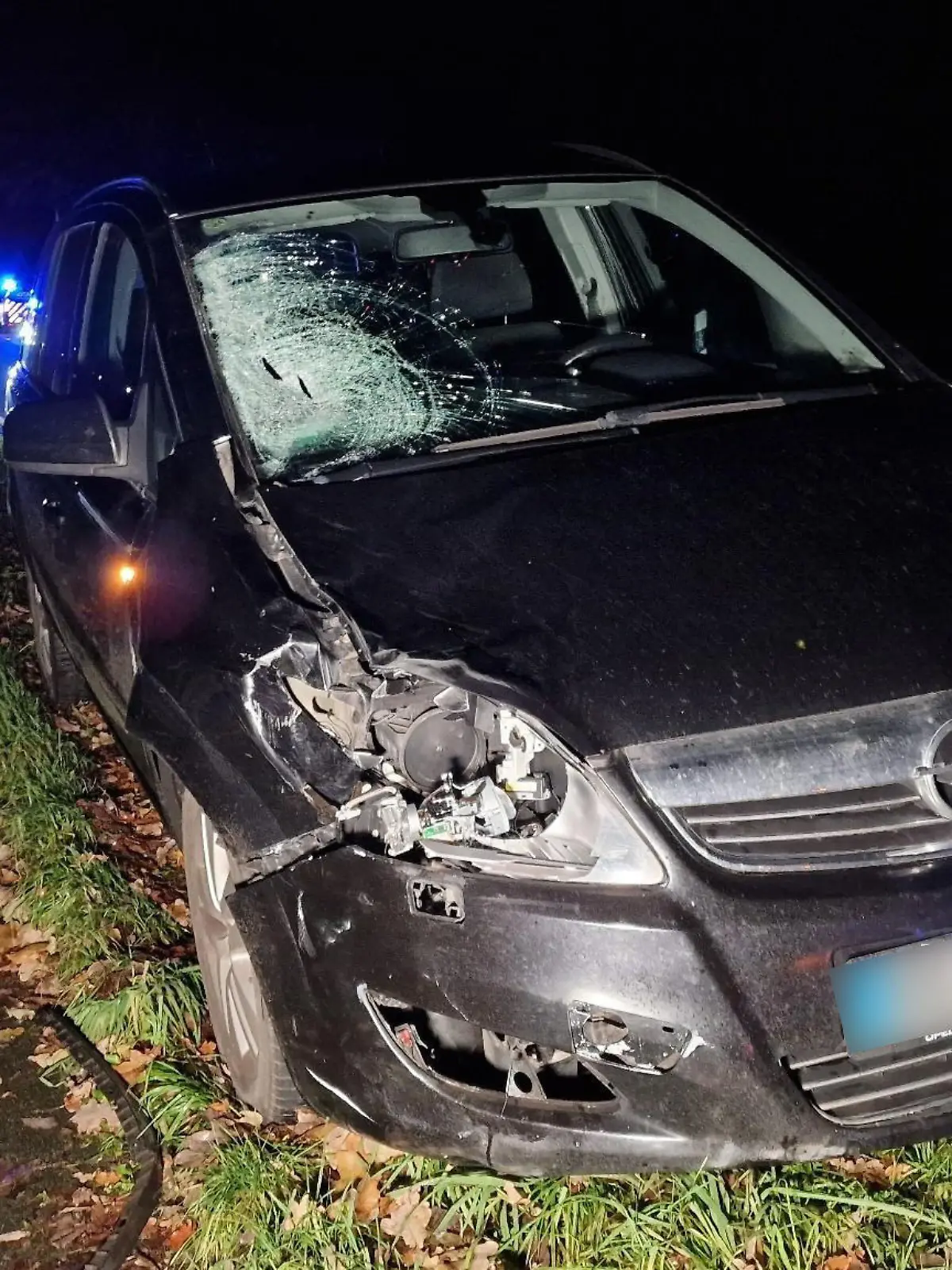 11.12.2023, Niedersachsen, Merzen: Die Scheibe eines Fahrzeuges ist beschädigt nach einem Unfall in Merzen. Ein Fußgänger ist im Landkreis Osnabrück beim Überqueren einer Fahrbahn von einem Auto erfasst und tödlich verletzt worden. Der Unfall passierte am Montagabend auf der Bundesstraße 218 in Merzen, einer Gemeinde innerhalb der Samtgemeinde Neuenkirchen, wie die Polizei mitteilte. Warum es zu dem Zusammenstoß kam, war noch unklar. Foto: NWM-TV/dpa - ACHTUNG: Das Kennzeichen wurde aus rechtlichen Gründen gepixelt. +++ dpa-Bildfunk +++