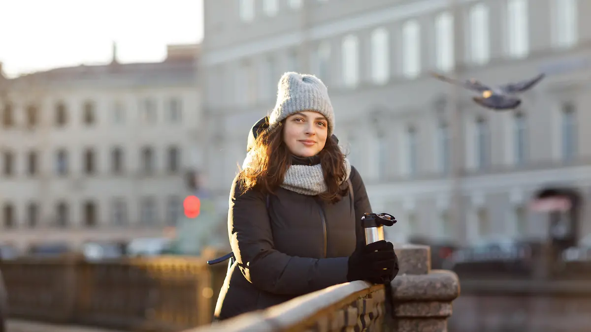 portrait of a woman in the city in a down jacket and a hat