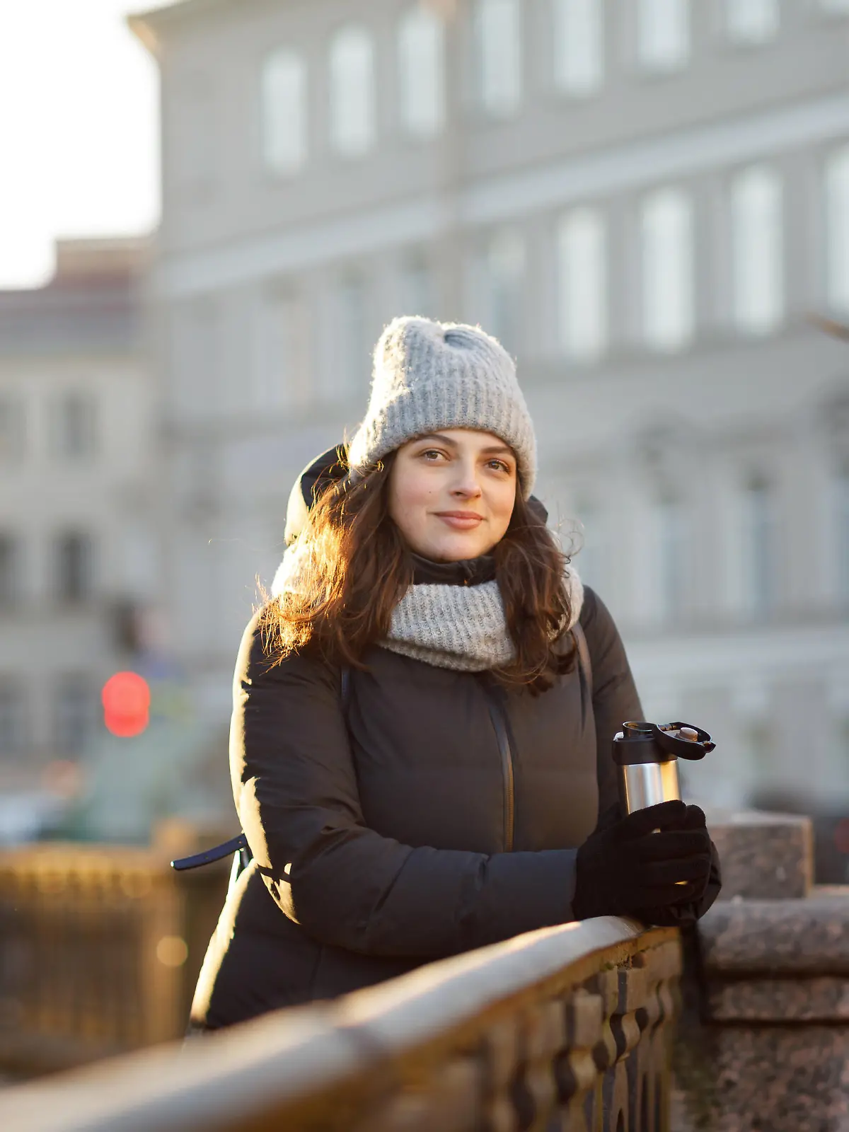portrait of a woman in the city in a down jacket and a hat