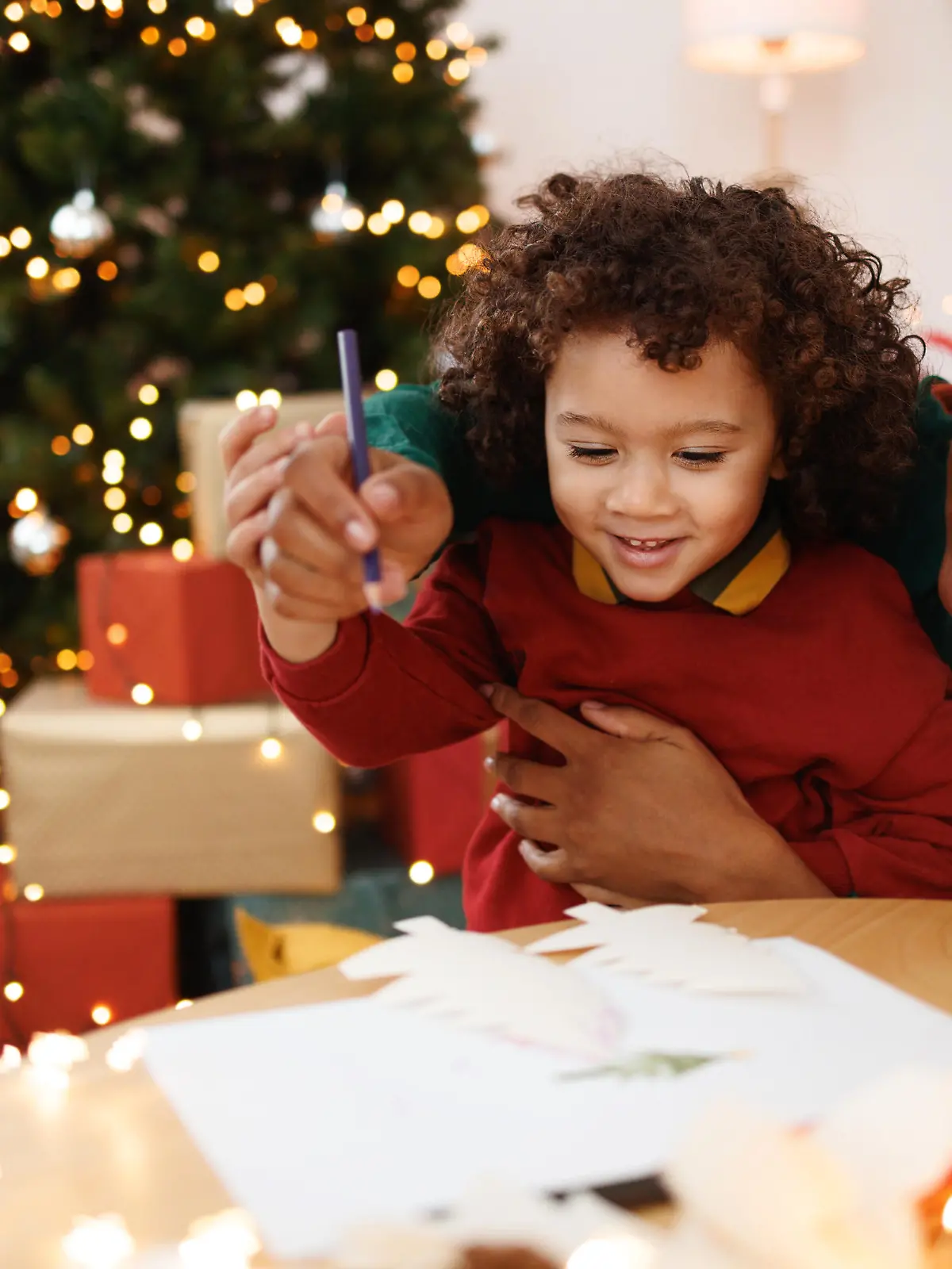 Mother and cute little son drawing together at the apartment during christams time
