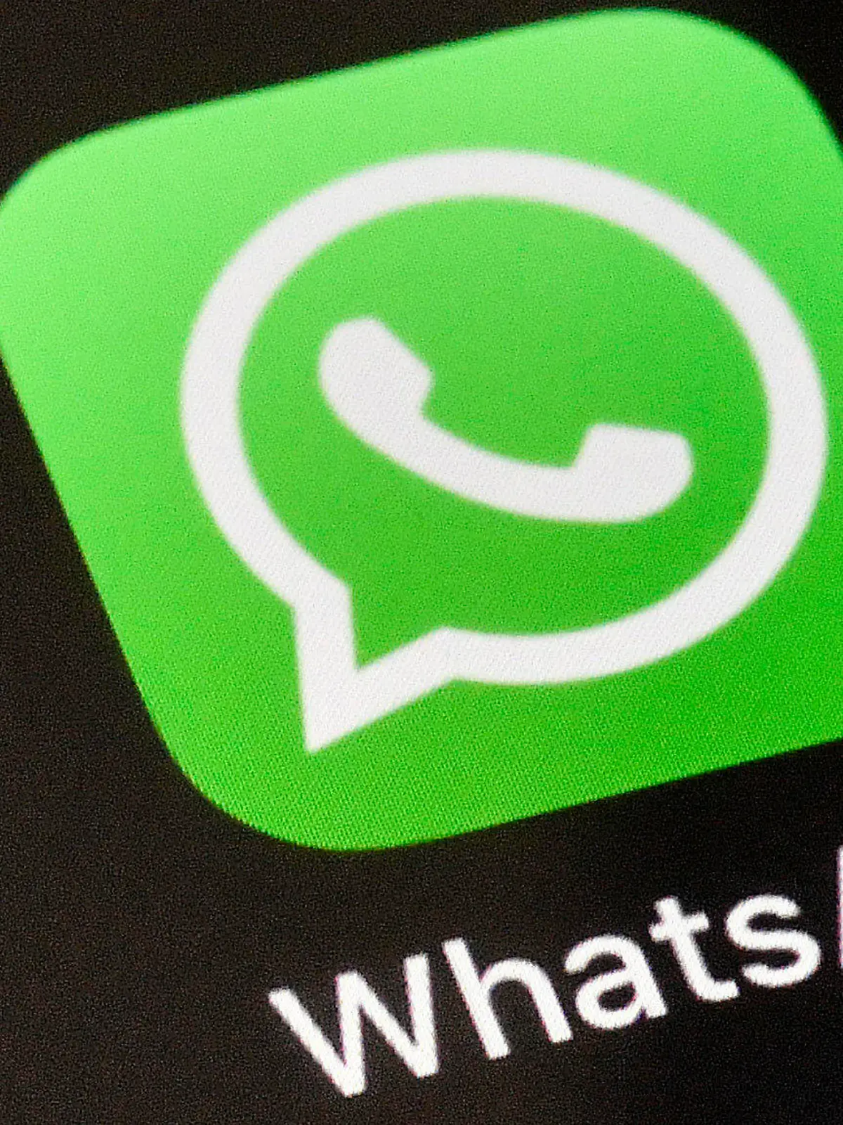 FILE - A WhatsApp icon is displayed on an iPhone, Thursday, Nov. 15, 2018 in Gelsenkirchen, Germany. WhatsApp has chosen the Mercedes Formula One team for its first sports sponsorship, a multi-year agreement that will give followers of the eight-time world champion exclusive team content and in-race updates through the Meta-owned private messaging service.  (AP Photo/Martin Meissner, File)