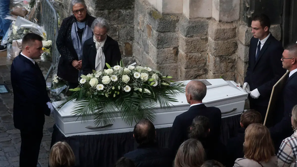 24.10.2022, Frankreich, Lillers: Menschen stehen am Ende der Beerdigungsfeier neben dem Sarg der zwölfjährigen Lola vor der Kirche von Lillers. Die Leiche des Mädchens war am 14.10.2022 mit Wunden am Hals in einem Koffer in einem Innenhof im Nordosten von Paris entdeckt worden. Foto: Michel Spingler/AP/dpa +++ dpa-Bildfunk +++