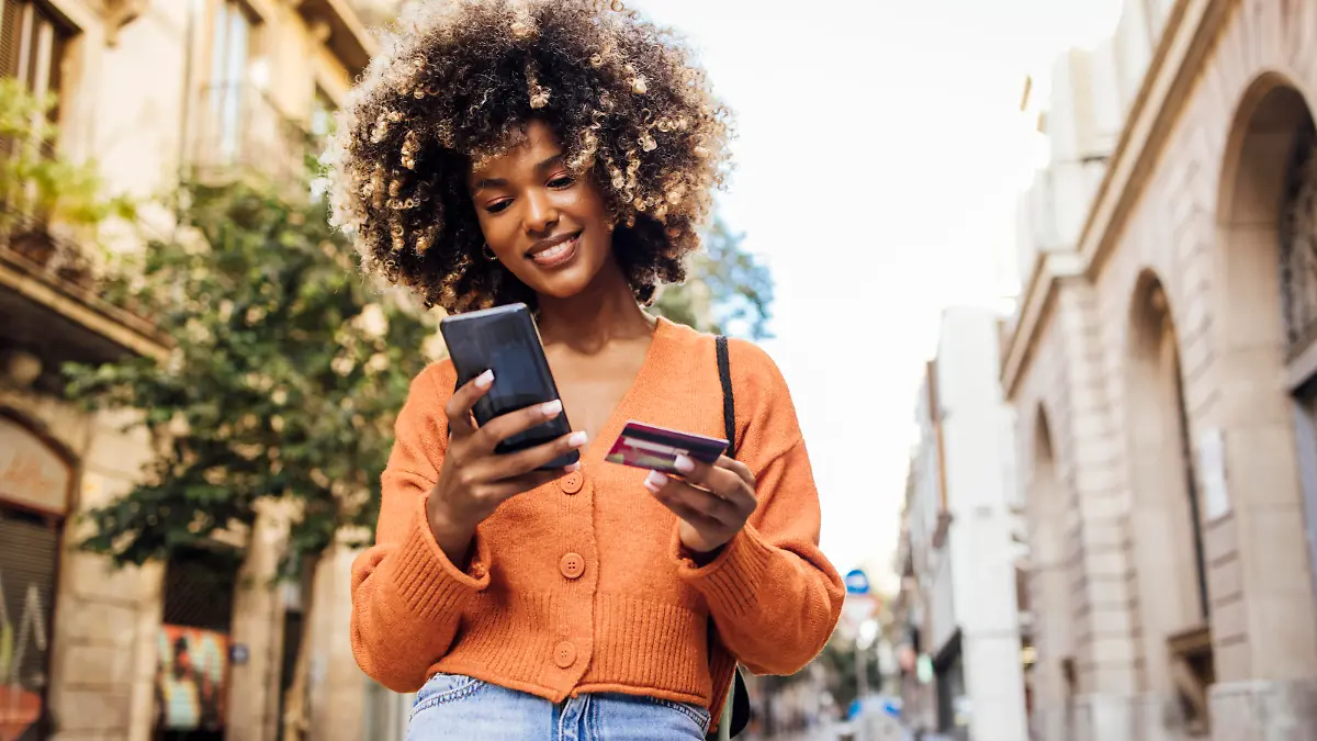 Portrait of a young African American woman on vacation in Barcelona shopping online on the street.