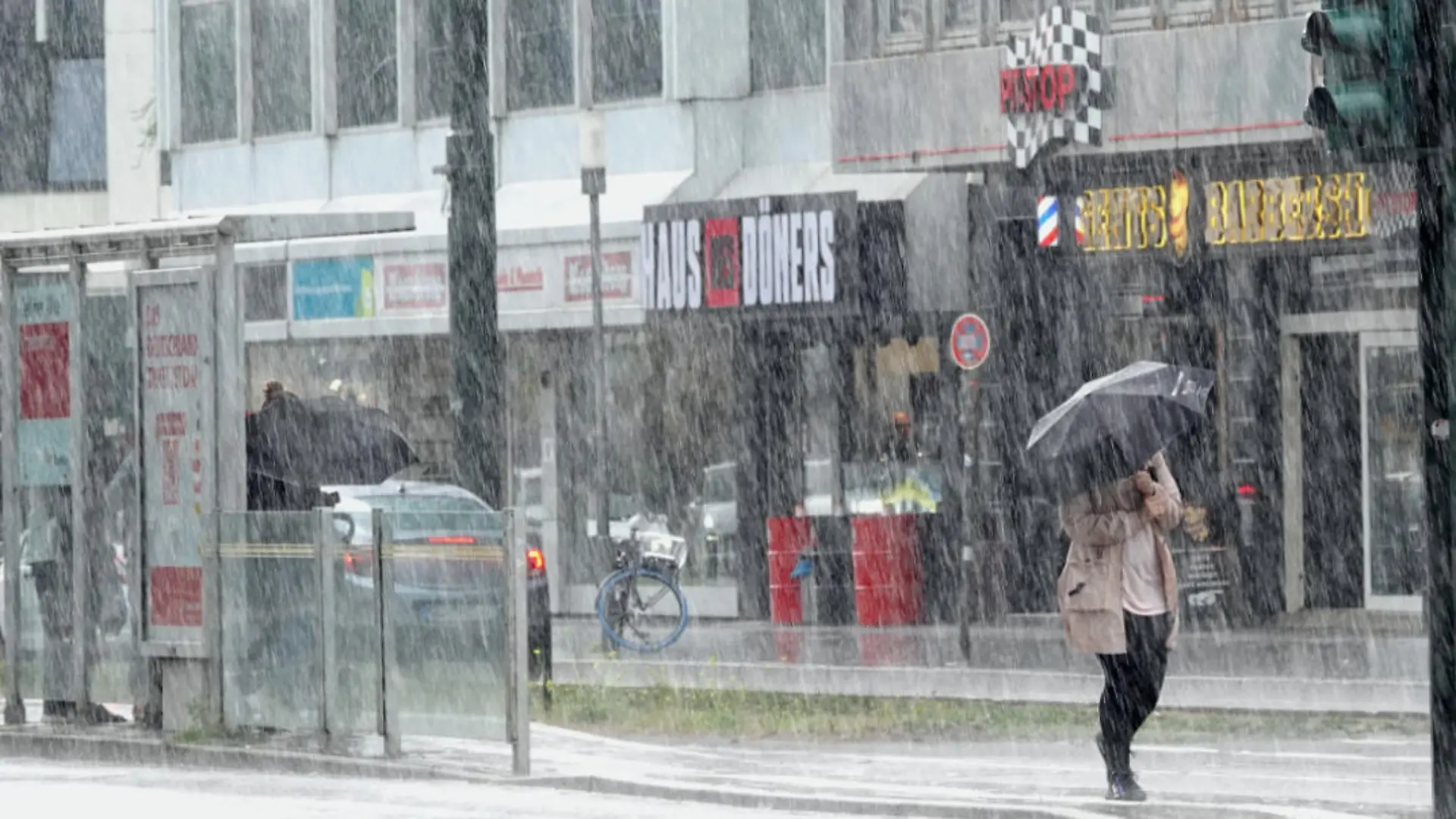 26.07.2023, Nordrhein-Westfalen, Düsseldorf: Eine Frau läuft im Regen durch die Düsseldorfer Innenstadt. Nach zuletzt durchwachsenem und oft grauem Wetter in Nordrhein-Westfalen geht es auch in den nächsten Tagen eher herbstlich als hochsommerlich weiter. (zu dpa «Herbstliches Wetter mitten im Hochsommer in NRW») Foto: Linda Henrich/dpa +++ dpa-Bildfunk +++