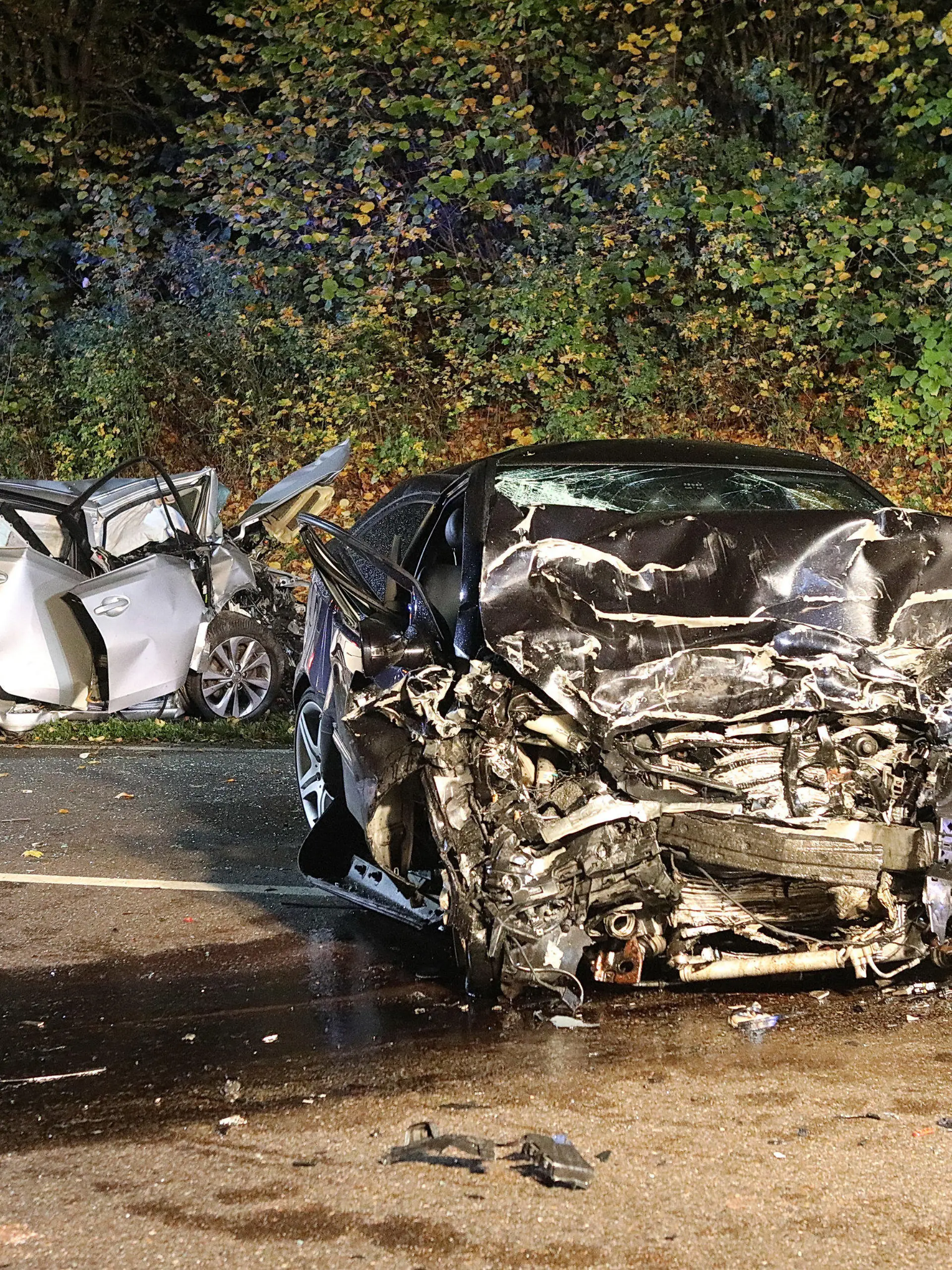 21.10.2022, Baden-Württemberg, Suppingen: Ein Feuerwehrmann steht zwischen den beiden stark zerstörten Wracks. Bei einem Frontalzusammenstoß der beiden Autos auf der B28 Höhe Suppingen (Alb-Donau-Kreis) sind die jeweiligen Fahrer gestorben. Ein 43-Jähriger und ein 62-Jähriger stießen am Freitagabend aus bislang ungeklärten Gründen bei starkem Regen mit ihren Fahrzeugen frontal zusammen. Foto: Ralf Zwiebler/dpa +++ dpa-Bildfunk +++