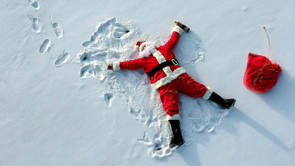 Drunk santa claus lying on the snow drone shot