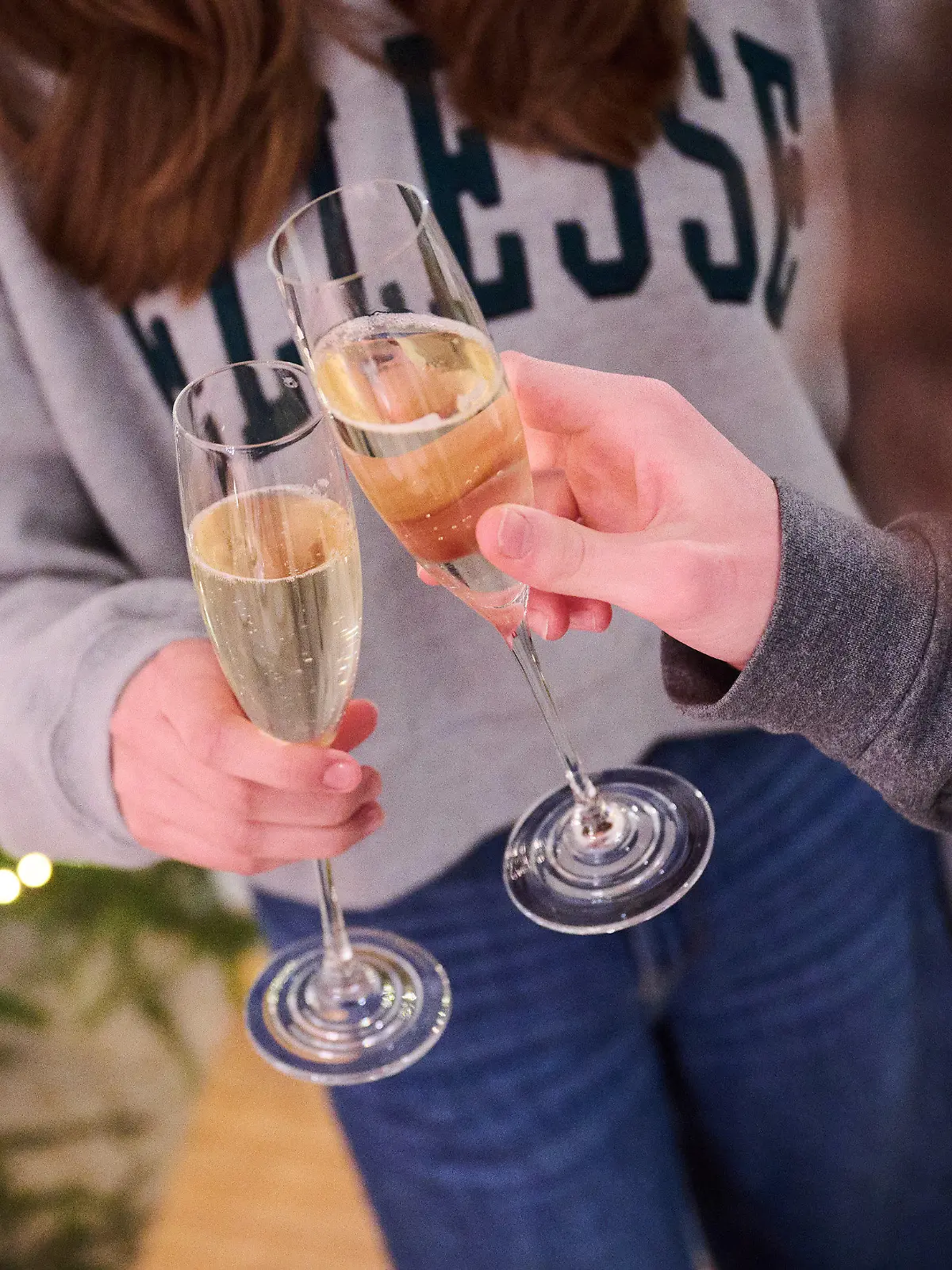 ARCHIV - 27.12.2022, Bayern, Freystadt: Zwei Personen stoßen zuhause neben einem Weihnachtsbaum mit Sekt an. (Illustration zu dpa: "Umfrage: Deutsche flüchten auch mit Alkohol vor dem Alltag") Foto: Annette Riedl/dpa +++ dpa-Bildfunk +++