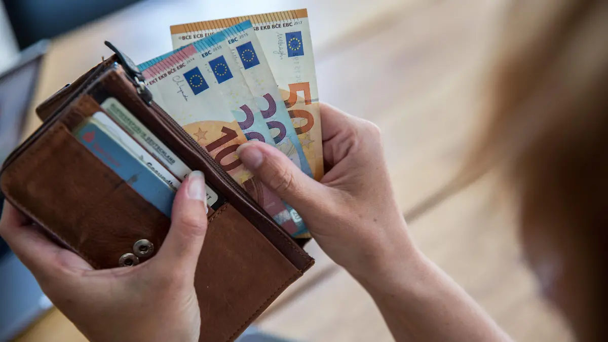 Bamberg, Deutschland 05. September 2023: Themenbilder - Symbolbilder - Geld - 2023 Eine Person hält eine Geldbörse, Portemonnaie, mit Bargeld in den Händen. Die Geldscheine haben die Währung Euro und sind von unterschiedlichem Geldwert, darunter 5 â, 10â, 20â und 50â. Bayern *** Bamberg, Germany 05 September 2023 Theme Images Iconic Images Money 2023 A person holds a purse, wallet, with cash in his hands The banknotes have the currency euro and are of different monetary value, including 5 â, 10â, 20â and 50â Bayern Copyright: xFotostandx/xK.xSchmittx