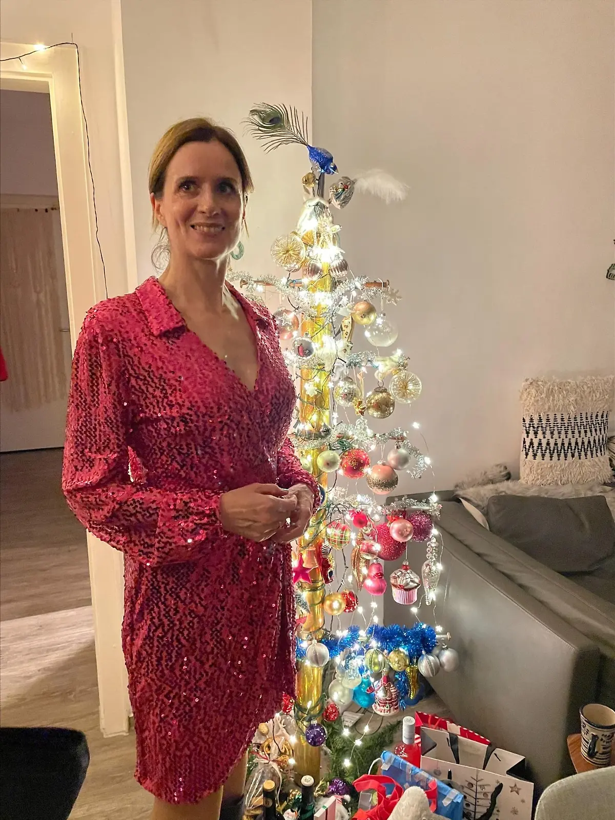 Maren Mangold steht im pinken Pailletten-Kleid vor einem Christbaum-Kugel-Gestell in Baum-Form.