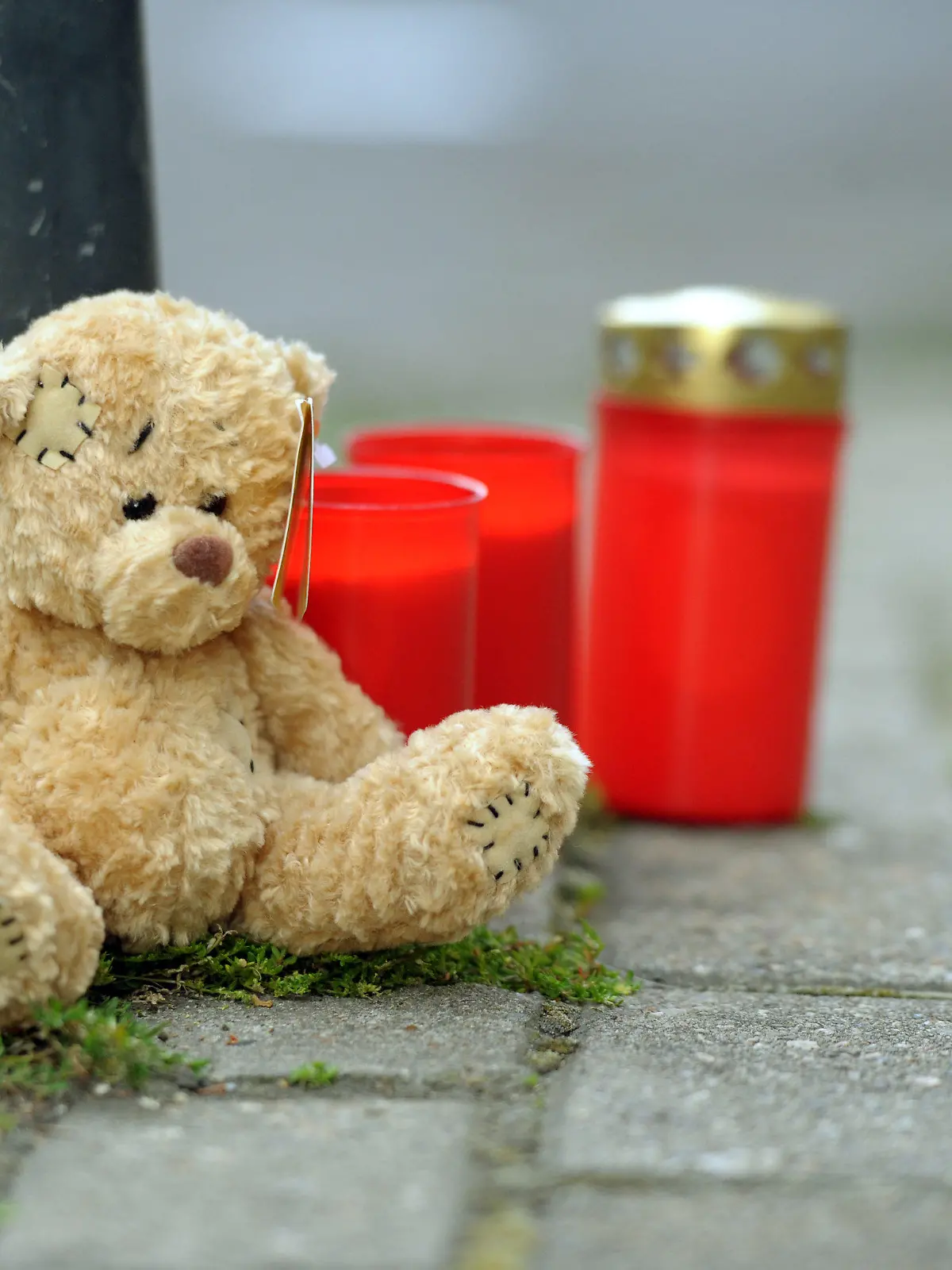 Ein Teddybär und Friedhofskerzen stehen am Donnerstag (09.08.2012) an einer Straßenecke in Oberhausen. Nach der Bluttat an einem achtjährigen Kind in Oberhausen hat die Polizei erste Details bekanntgegeben. Demnach ging der 27 Jahre alte Verdächtige im Kinderzimmer mit einem Messer auf den Jungen los. Das Kind starb später im Krankenhaus. Foto: Caroline Seidel dpa/lnw (zu dpa 0346 vom 09.08.2012)  +++(c) dpa - Bildfunk+++
