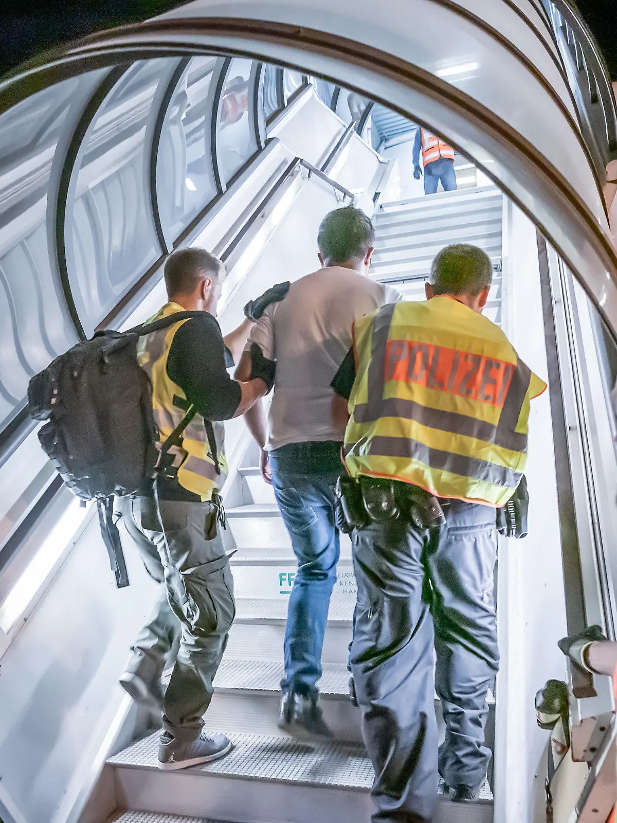ARCHIV - 30.07.2019, Sachsen, Leipzig: Polizeibeamte begleiten einen Afghanen auf dem Flughafen Leipzig-Halle in ein Charterflugzeug. (zu dpa: «Pro Asyl hält Abschiebung nach Afghanistan für unverantwortlich») Foto: Michael Kappeler/dpa +++ dpa-Bildfunk +++
