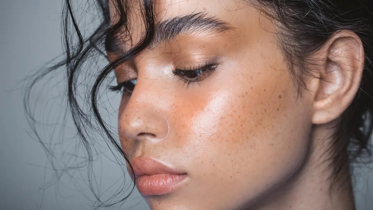 Close up studio shot of a beautiful young woman with perfect glow skin.