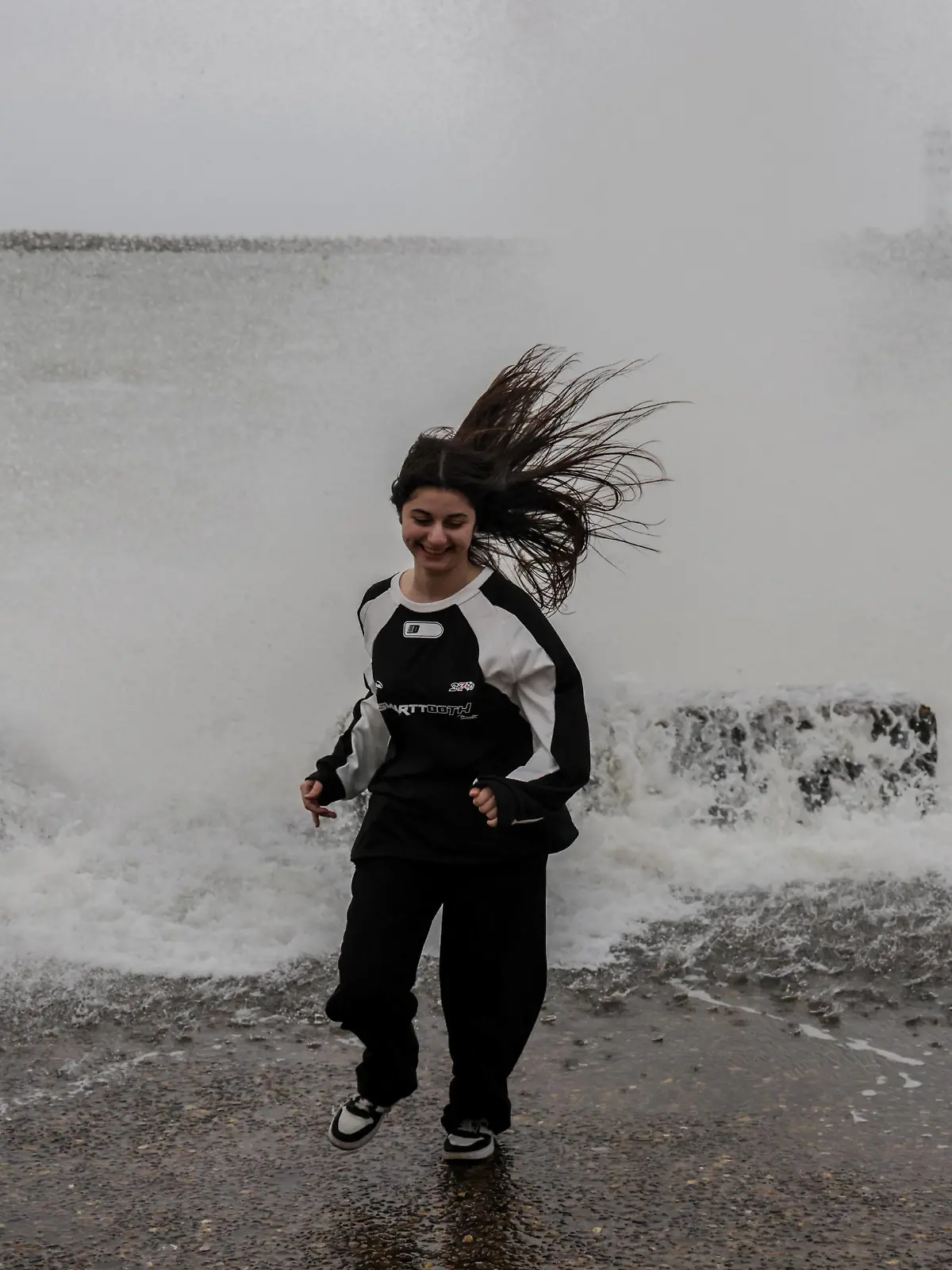 RUSSIA, SOCHI - NOVEMBER 26, 2023: A girl reacts as high winds and waves hit the resort of Sochi during a storm at Russia s Black Sea coast. Dmitry Feoktistov/TASS PUBLICATIONxINxGERxAUTxONLY 65229613