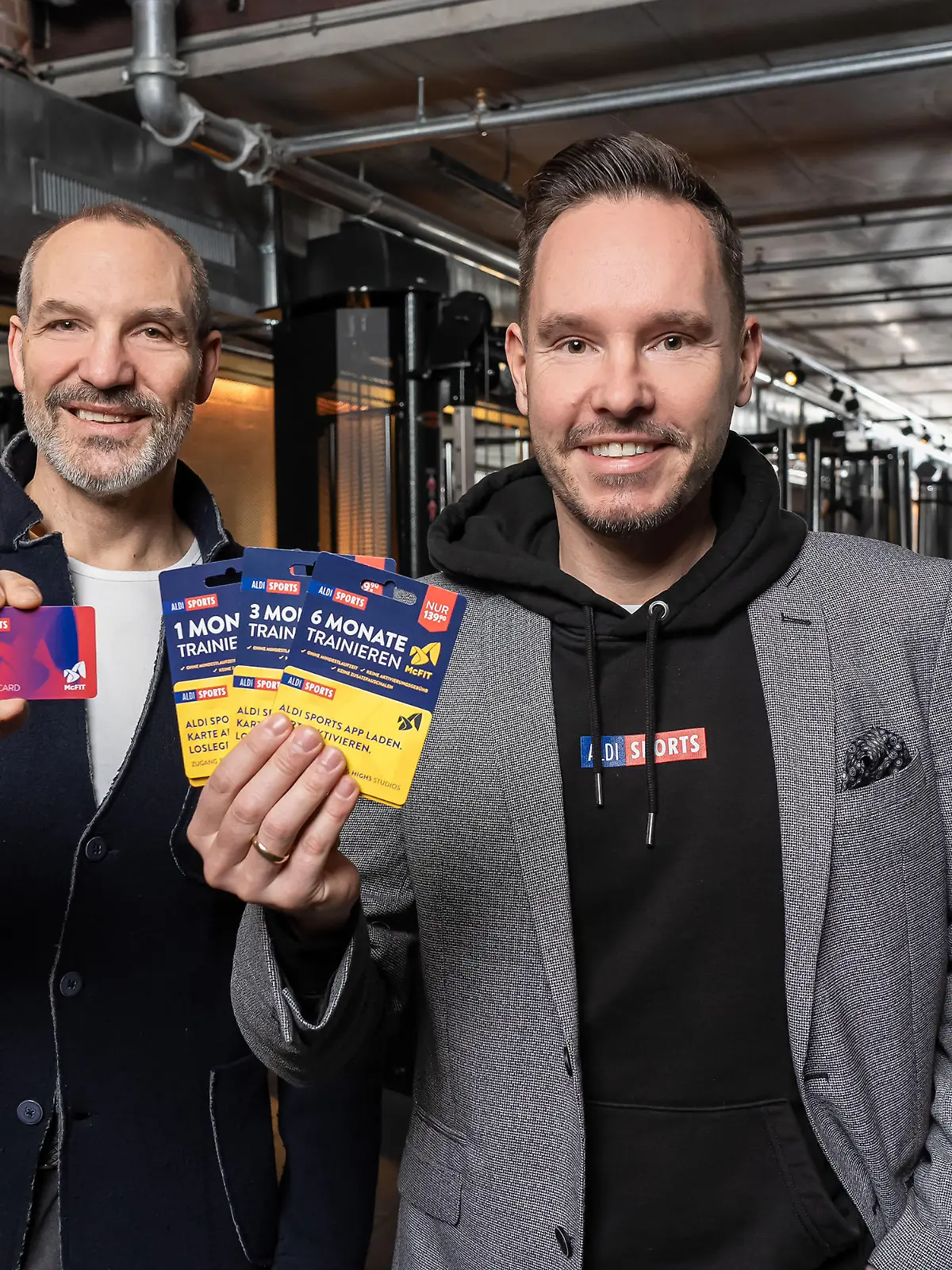 McFit-Chef Hagen Wingertszahn und Aldi-Manager Kai Schmidhuber stellen die neuen Aldi-McFit-Pakete vor.