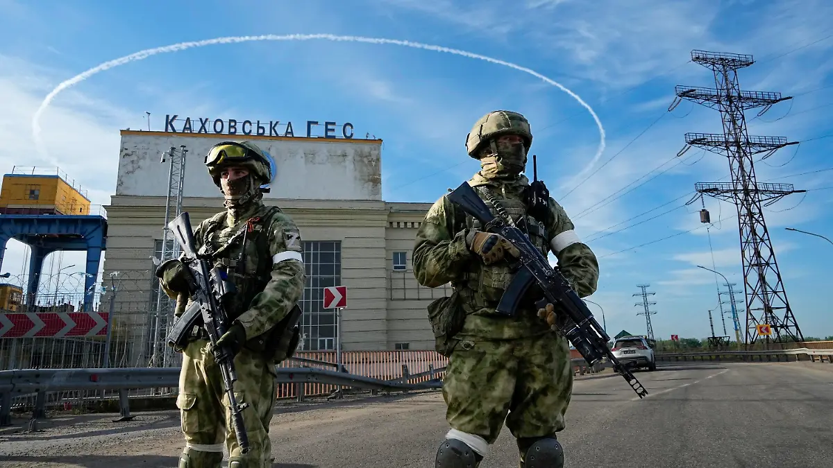 20.05.2022, Ukraine, Nowa Kachowka: Zwei russische Soldaten bewachen während einer vom russischen Verteidigungsministerium organisierten Reise einen Eingang des Wasserkraftwerks Kachowka, eines Laufwasserkraftwerks am Dnjepr. Die Region Cherson steht seit Beginn der russischen Invasion in die Ukraine unter der Kontrolle der russischen Streitkräfte. Foto: Uncredited/AP/dpa +++ dpa-Bildfunk +++
