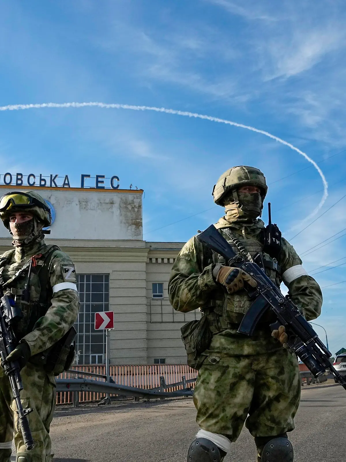 20.05.2022, Ukraine, Nowa Kachowka: Zwei russische Soldaten bewachen während einer vom russischen Verteidigungsministerium organisierten Reise einen Eingang des Wasserkraftwerks Kachowka, eines Laufwasserkraftwerks am Dnjepr. Die Region Cherson steht seit Beginn der russischen Invasion in die Ukraine unter der Kontrolle der russischen Streitkräfte. Foto: Uncredited/AP/dpa +++ dpa-Bildfunk +++