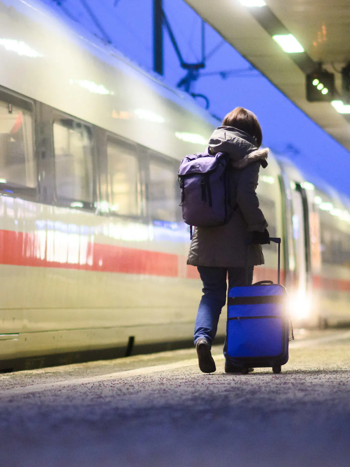 08.12.2023, Niedersachsen, Hannover: Eine Frau geht mit einem Koffer neben einem ICE im Hauptbahnhof Hannover. Die Gewerkschaft Deutscher Lokomotivführer (GDL) hatte zu einem weiteren, 24-stündigen Warnstreik bei der Deutschen Bahn AG aufgerufen. Foto: Julian Stratenschulte/dpa +++ dpa-Bildfunk +++