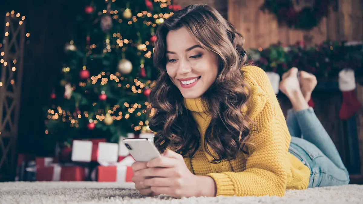 Low below angle view photo of charming, cute beautiful attractive girlfriend browsing through her phone in search of something while wearing jeans denim yellow sweater