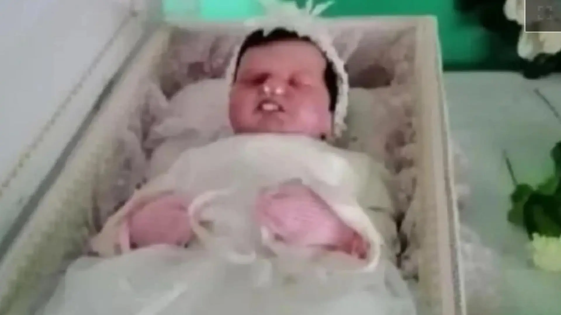 Eine Puppe in einem geöffneten Kindersarg