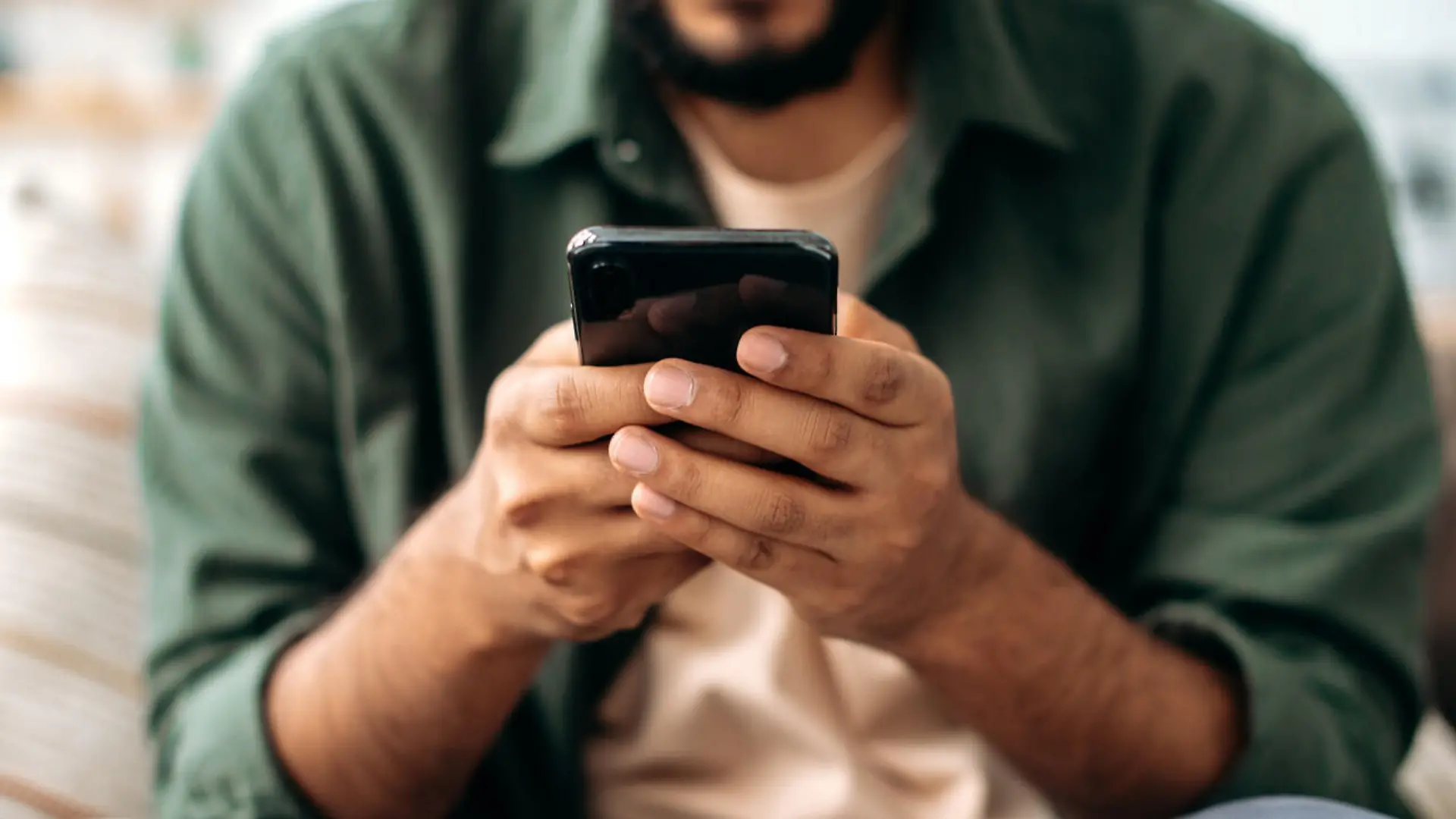 Close-up of a smartphone in a male hands. The concept of online messaging, social media communication, browsing the internet, websites, reading news. Wireless technologies, gadgets