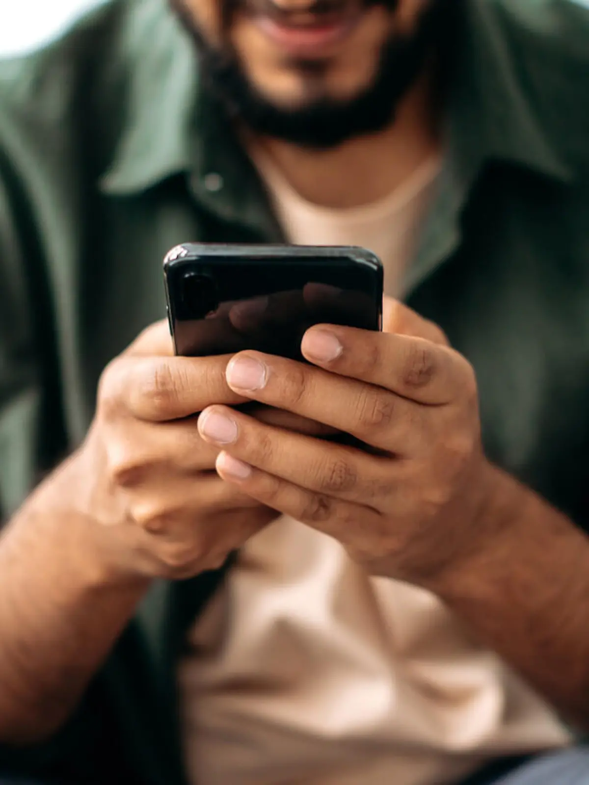 Close-up of a smartphone in a male hands. The concept of online messaging, social media communication, browsing the internet, websites, reading news. Wireless technologies, gadgets