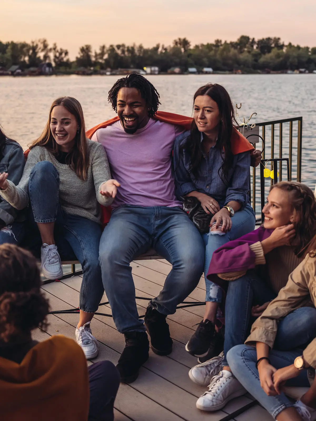 Group of Millennials  having fun at the deck of houseboat. End of the summer weekend party.