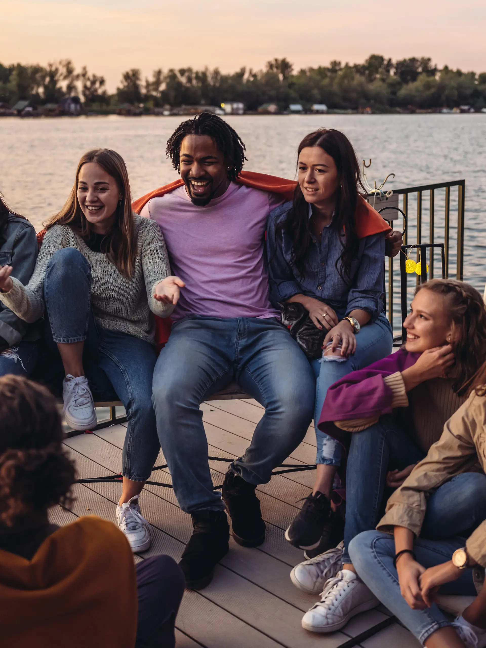 Group of Millennials  having fun at the deck of houseboat. End of the summer weekend party.