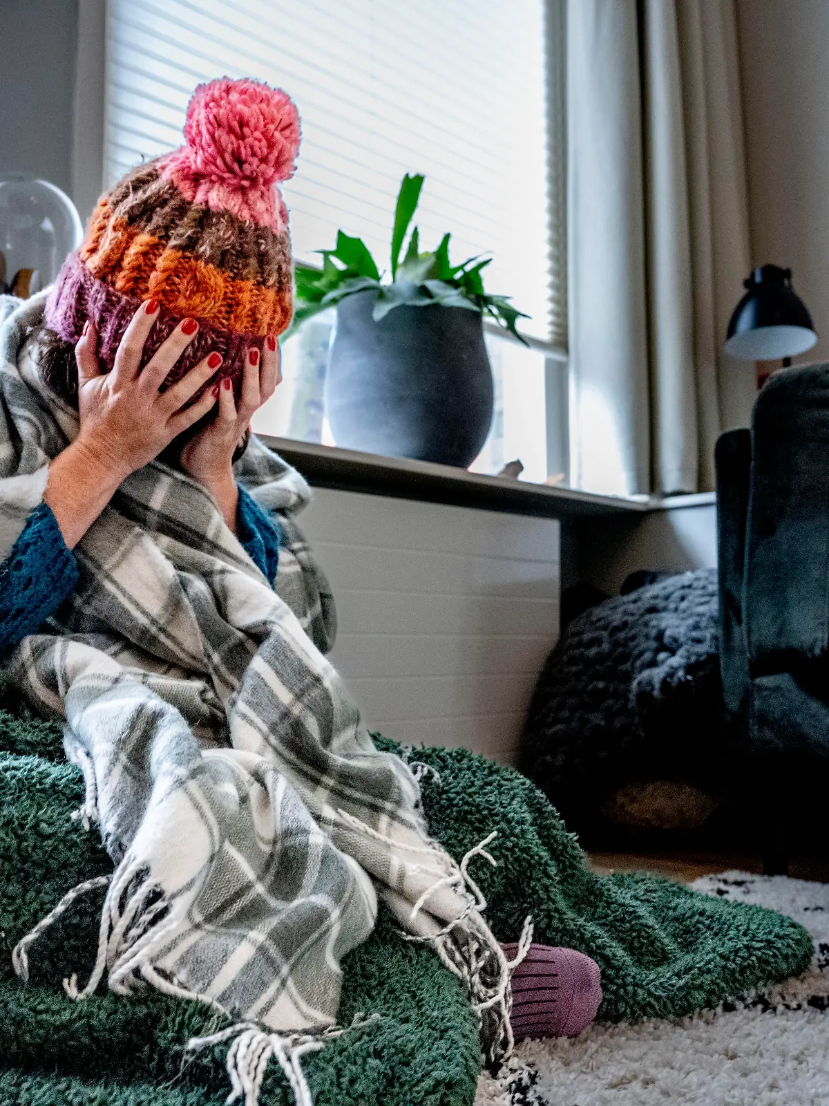 ILLUSTRATIVE - A woman is sitting with a blanket in her home because of the high gas and energy prices, they have to start shutting down. Now that inflation is unprecedentedly high and more and more families and companies are in danger of getting into trouble due to the high energy prices, the government is proposing a temporary price ceiling for gas and electricity. Robin Utrecht

