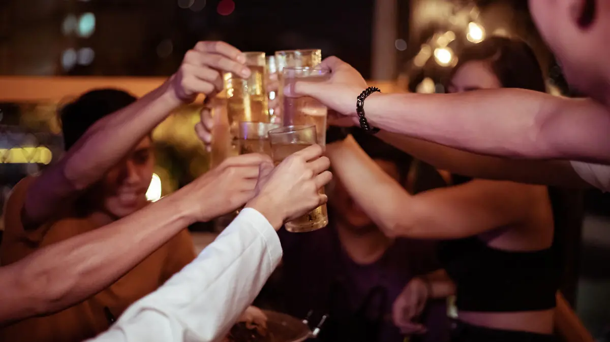 Group of young people hands toasting and cheering aperitif beers
