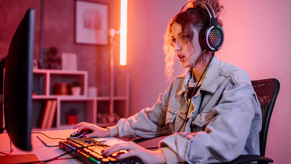 Young woman live streaming while playing multiplayer online game in living room at home