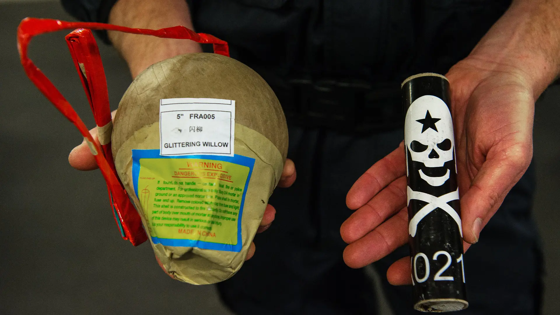 Ein Polizeibeamter vom Landeskriminalamt hält am 07.12.2016 in Mainz (Rheinland-Pfalz) zwei illegalen Feuerwerkskörper, eine Kugelbombe und einen Böller mit Totenkopf, in seinen Händen. Illegale Feuerwerkskörper sind häufig mit wesentlich höheren Sprengstoffmengen gefüllt und können schwere- oder sogar tödliche Verletzungen verursachen. Foto: Andreas Arnold/dpa