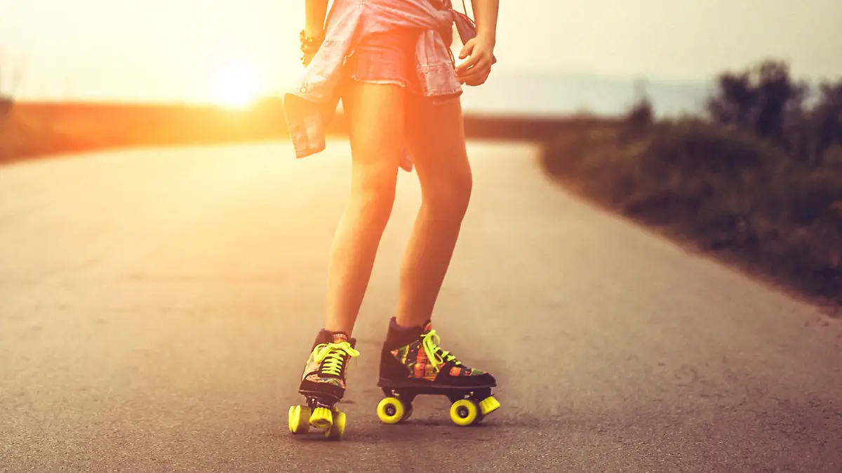 Young woman on roller skates skating into sunset