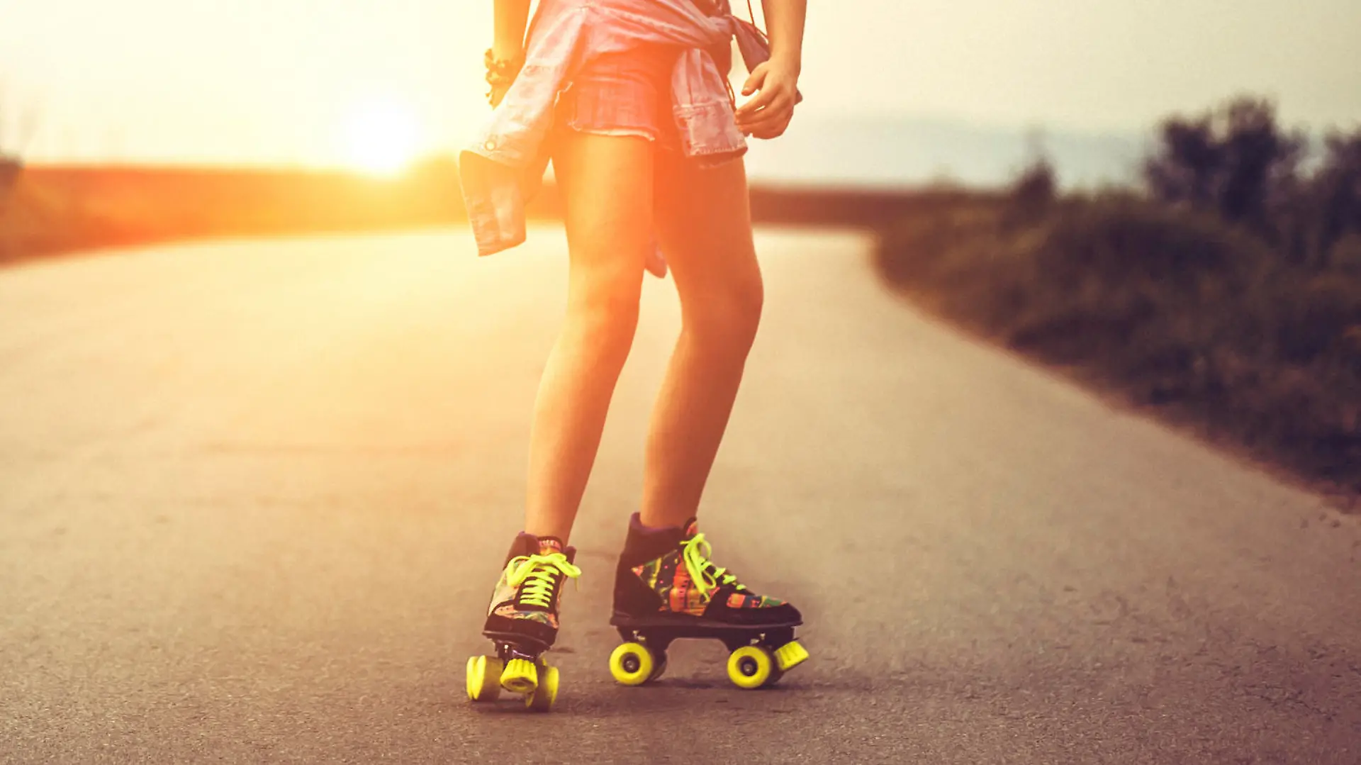 Young woman on roller skates skating into sunset