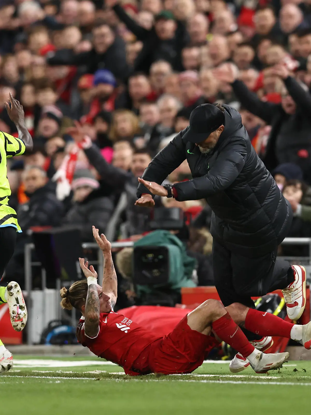 Liverpool, England, 23rd December 2023. Kostas Tsimikas of Liverpool challenges Bukayo Saka of Arsenal and goes crashing into Jurgen Klopp manager of Liverpool leading to Tsimikas injury during the Premier League match at Anfield, Liverpool. Picture credit should read: Darren Staples / Sportimage EDITORIAL USE ONLY. No use with unauthorised audio, video, data, fixture lists, club/league logos or live services. Online in-match use limited to 120 images, no video emulation. No use in betting, games or single club/league/player publications. SPI-2829-0038