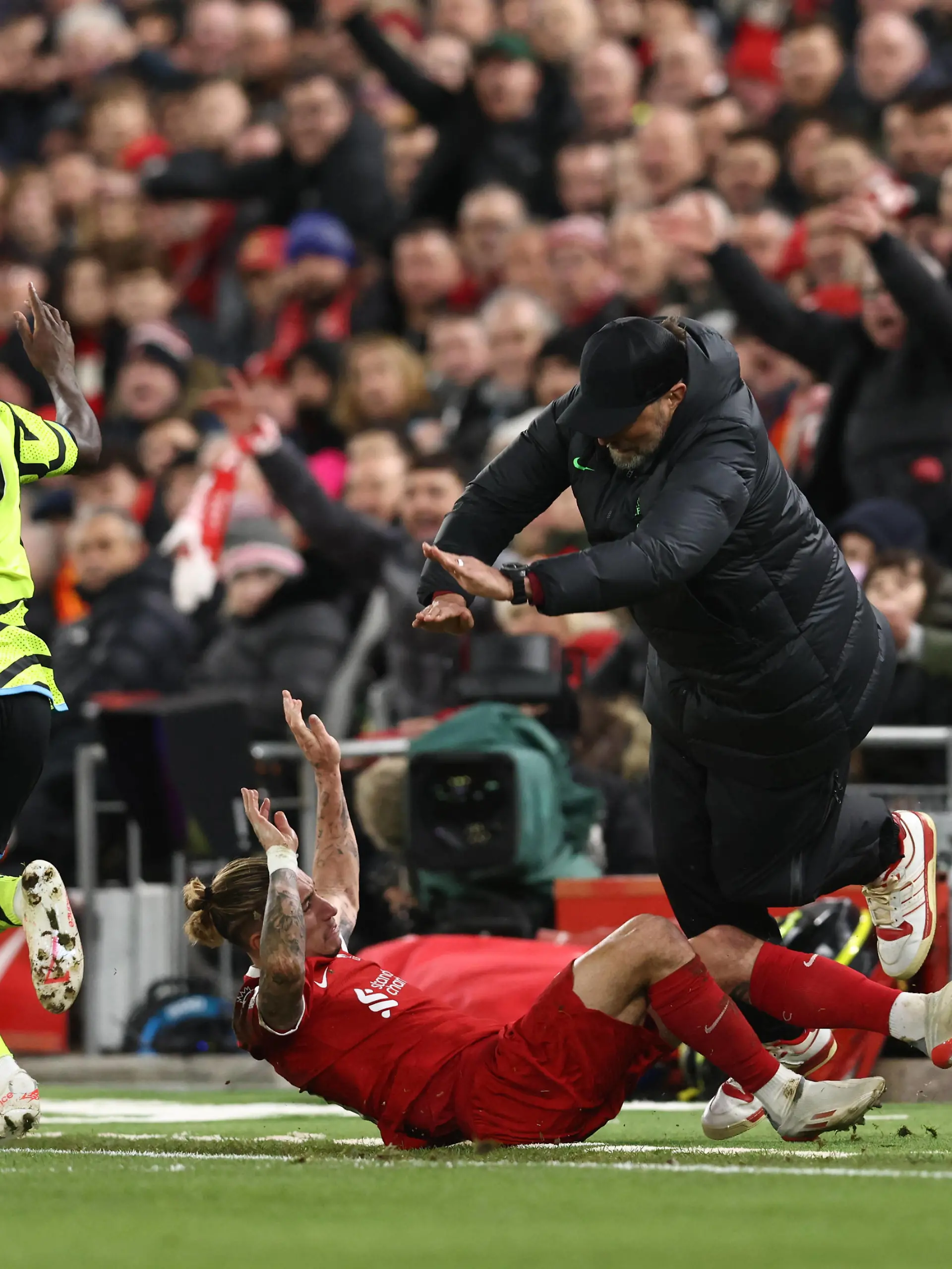 Liverpool, England, 23rd December 2023. Kostas Tsimikas of Liverpool challenges Bukayo Saka of Arsenal and goes crashing into Jurgen Klopp manager of Liverpool leading to Tsimikas injury during the Premier League match at Anfield, Liverpool. Picture credit should read: Darren Staples / Sportimage EDITORIAL USE ONLY. No use with unauthorised audio, video, data, fixture lists, club/league logos or live services. Online in-match use limited to 120 images, no video emulation. No use in betting, games or single club/league/player publications. SPI-2829-0038