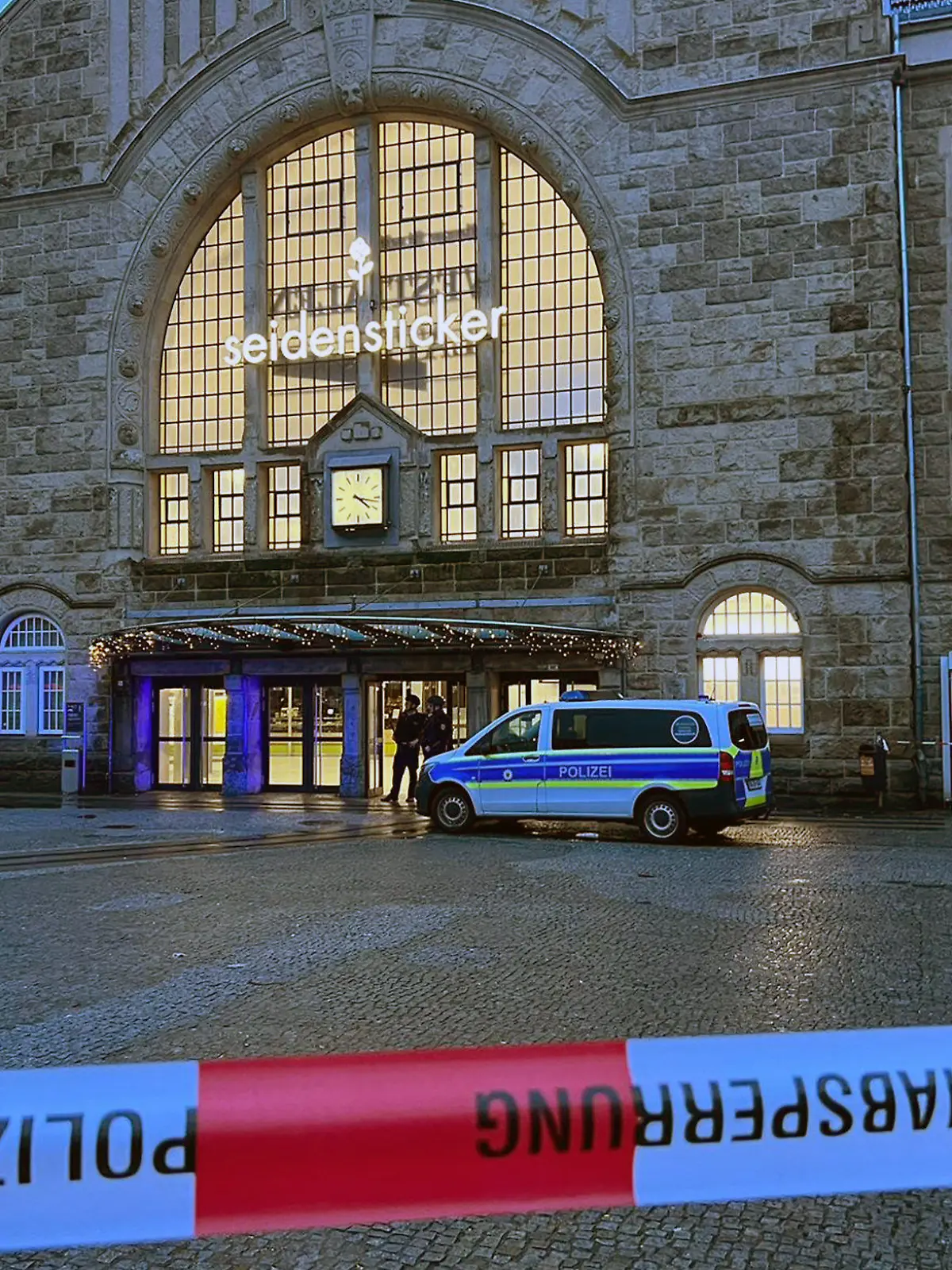 25.12.2023, Nordrhein-Westfalen, Bielefeld: Einsätzkräfte der Polizei stehen vor dem Bielefelder Hauptbahnhof. Wegen eines größeren Polizeieinsatzes ist der Bielefelder Hauptbahnhof weiträumig abgesperrt worden. Foto: Christian Müller/Wetfalennews/dpa +++ dpa-Bildfunk +++