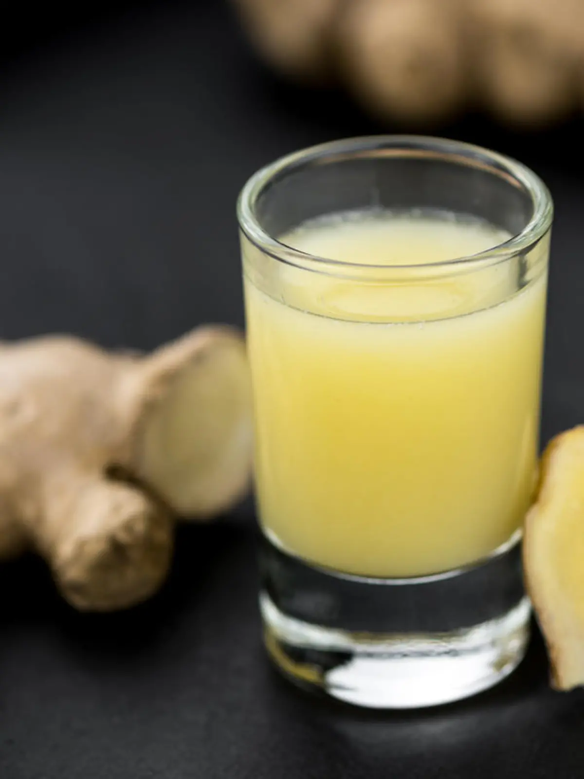 Portion of fresh Ginger Juice (selective focus; close-up shot)