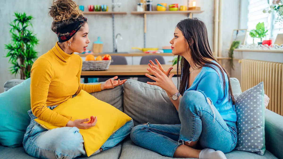 Two young female friends arguing at home
