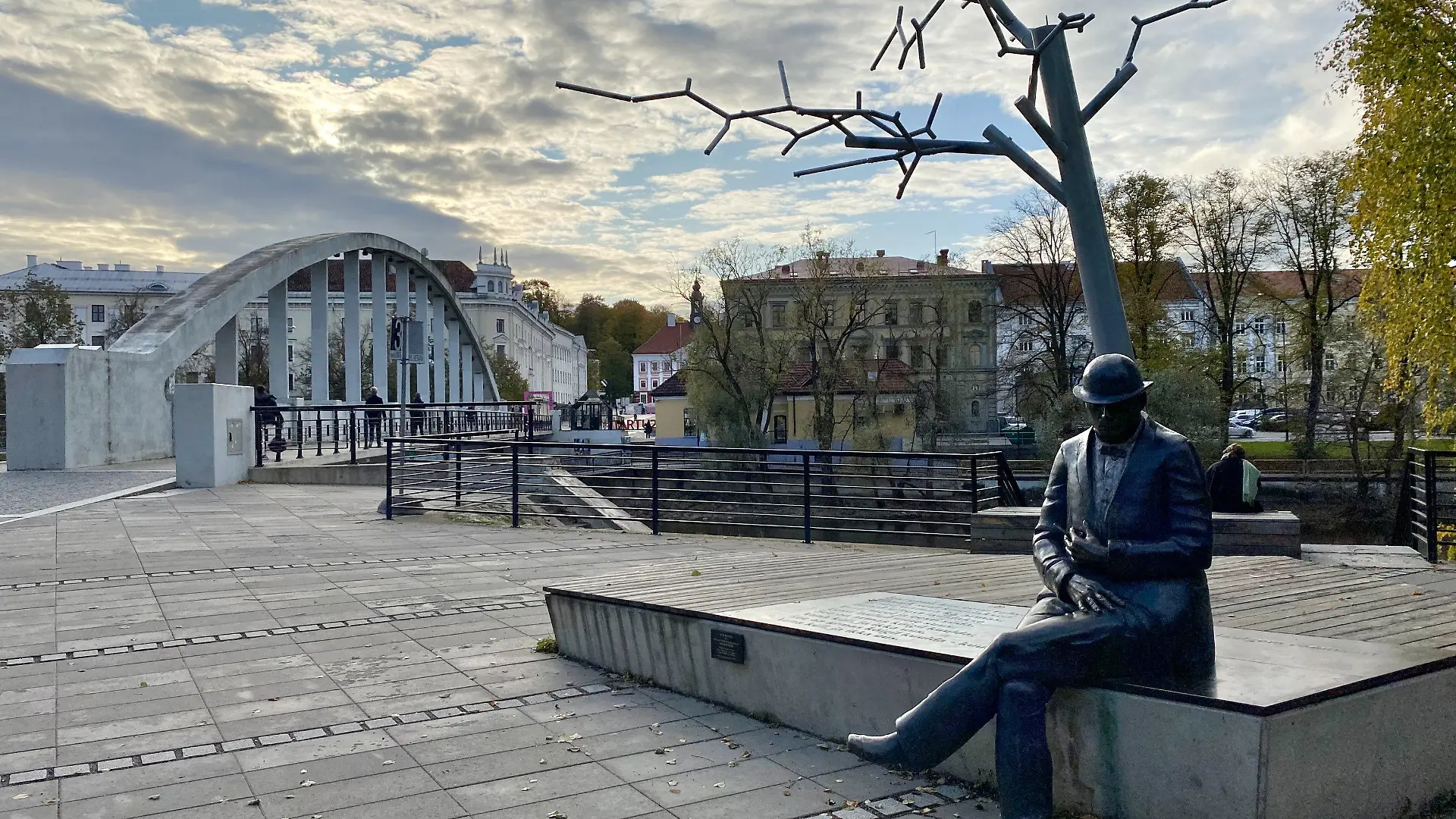 PRODUKTION - 20.10.2023, Estland, Tartu: Das Denkmal für den estnischen Journalisten und Dichter Johann Voldemar Jannsen mit der Bogenbrücke im Hintergrund. Estlands zweitgrößte Stadt Tartu wird 2024 Europäische Kulturhauptstadt. Foto: Alexander Welscher/dpa +++ dpa-Bildfunk +++