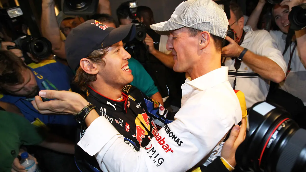 ARCHIV - 14.11.2010, Vereinigte Arabische Emirate, Abu Dhabi: Der deutsche Formel-1-Rennfahrer Sebastian Vettel (l) vom Team Red Bull wird nach seinem WM-Sieg von Michael Schumacher (Mercedes GP) beglückwünscht.  Sein Skiunfall jährt sich in diesem Monat zum zehnten Mal. (zu dpa: «Michael Schumacher: Ein Jahrzehnt der Erinnerung») Foto: Jens Büttner/dpa +++ dpa-Bildfunk +++