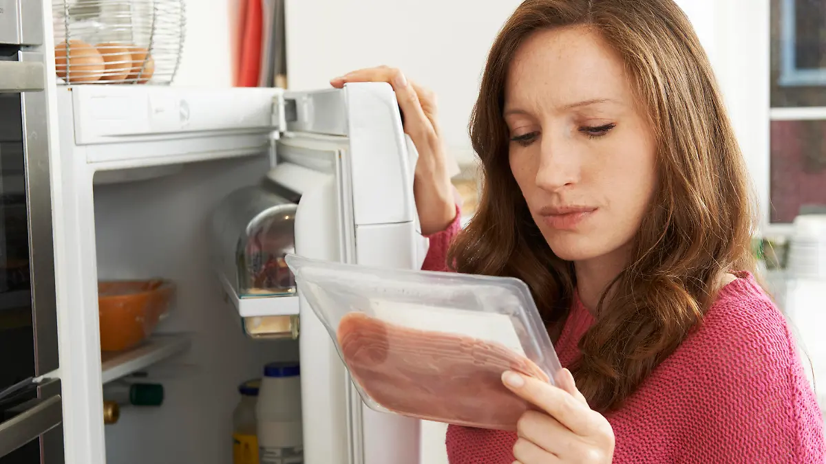 Concerned Woman Looking At Pre Packaged Meat